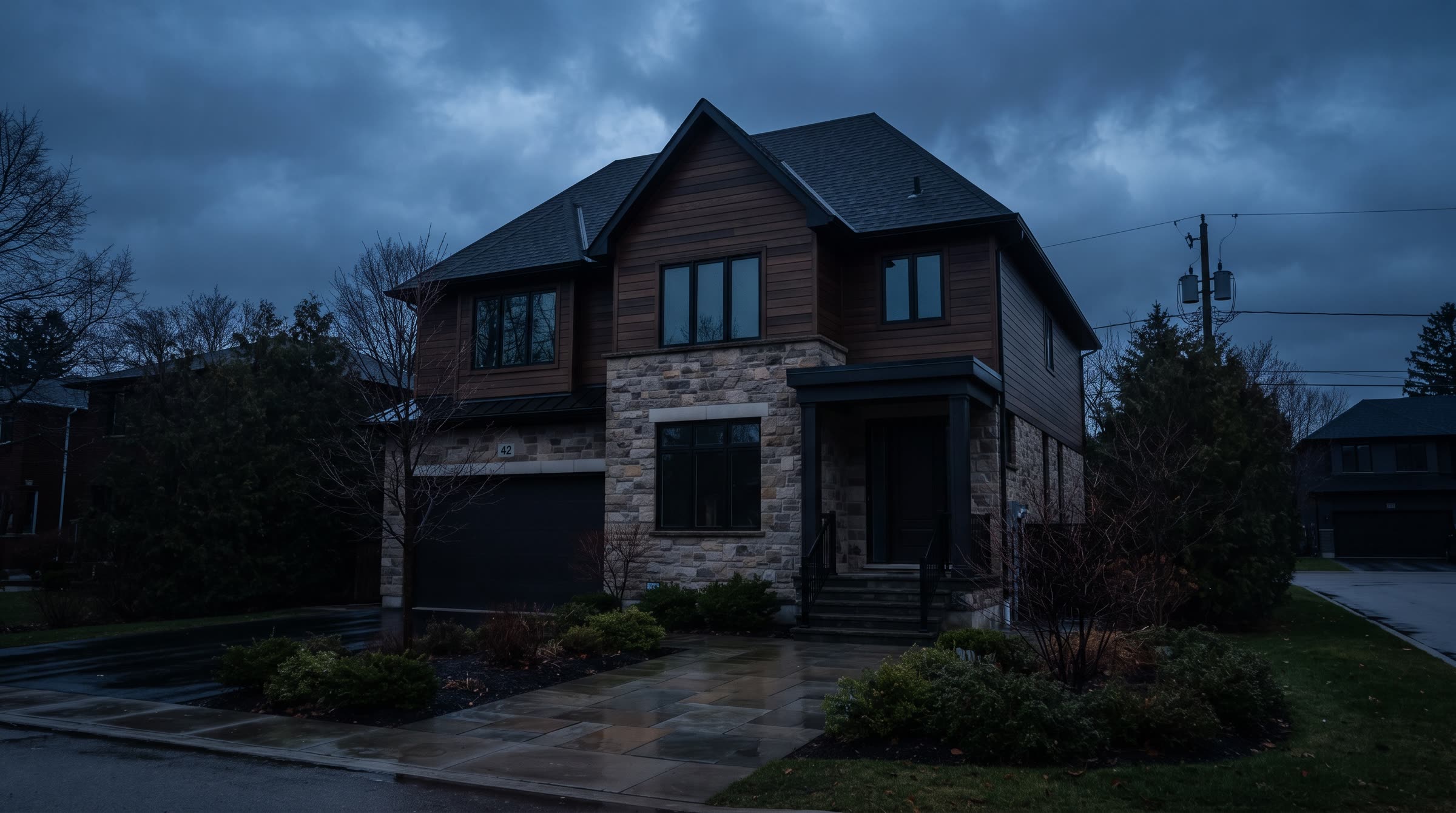 A two-storey house standing dark under storm clouds at dusk